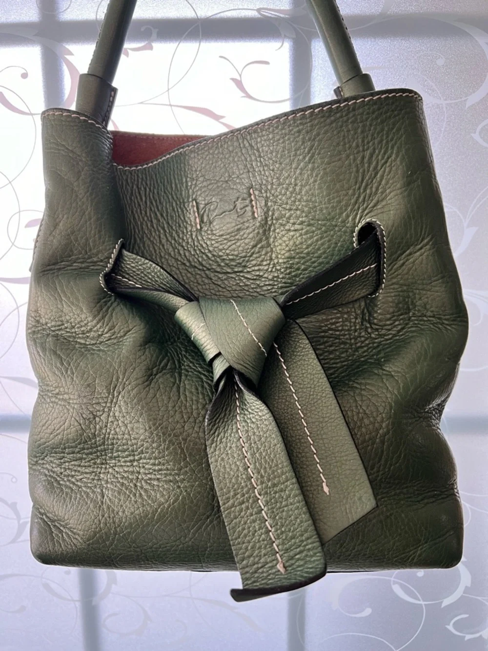 Tramontano hand bag in a pebbled green with a slight shimmer. Magnetic closure.